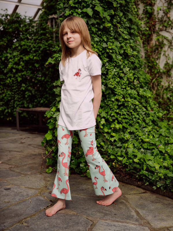 Girl with white TShirt with FLAMINGON print on chest and a pink Flares with FLAMINGON print
